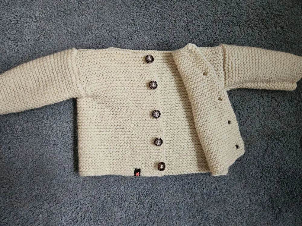 nullStrickjacke Baby Wollweiß Größe 68/74 6-9 monthStrickjacke Baby Wollweiß in Größe 68/74. Unsere handgestrickte Baby Strickjacke aus weicher Wolle in Wollweiß ist perfekt für die kalten Tage geeignet. Die Jacke is