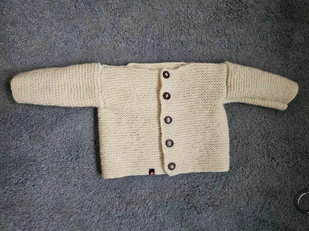nullStrickjacke Baby Wollweiß Größe 68/74 6-9 monthStrickjacke Baby Wollweiß in Größe 68/74. Unsere handgestrickte Baby Strickjacke aus weicher Wolle in Wollweiß ist perfekt für die kalten Tage geeignet. Die Jacke is