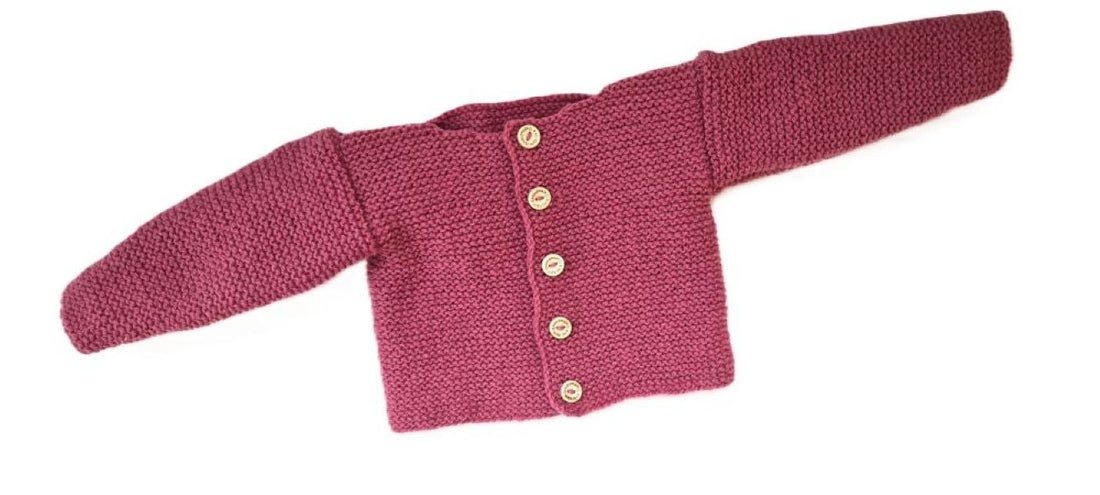 Eine Rosa farbene Bio Strickjacke für Babys
